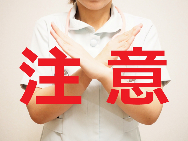 注意の赤文字と両手でバツする女性