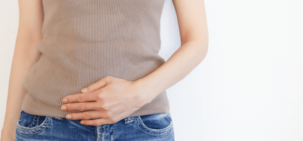 お腹に手を当てる女性