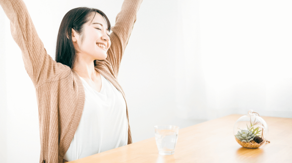 爽快な表情で両手を上に広げる女性